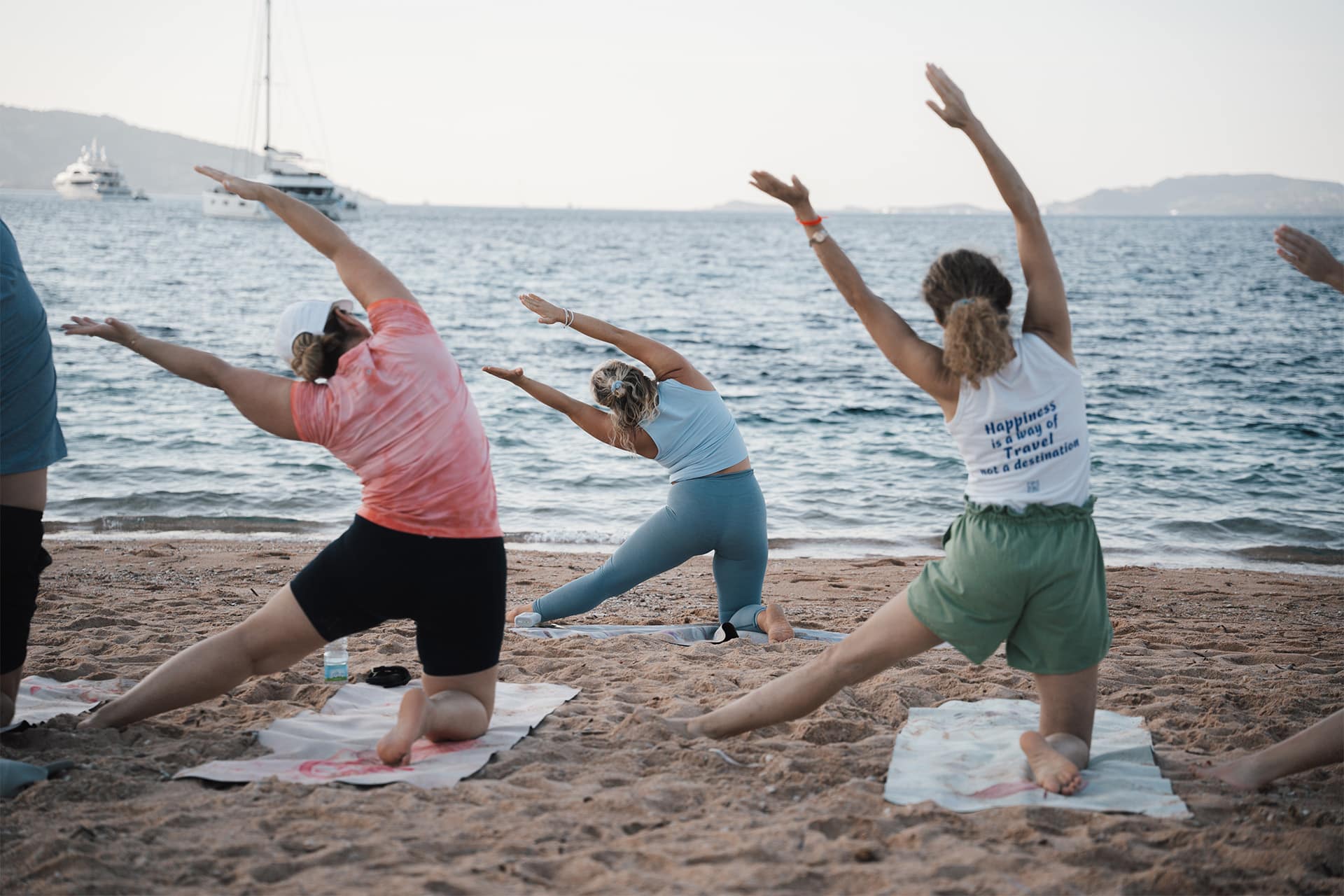 Agave guests doing yoga on the beach with guide, Sardinia, Italy, La Maddalena