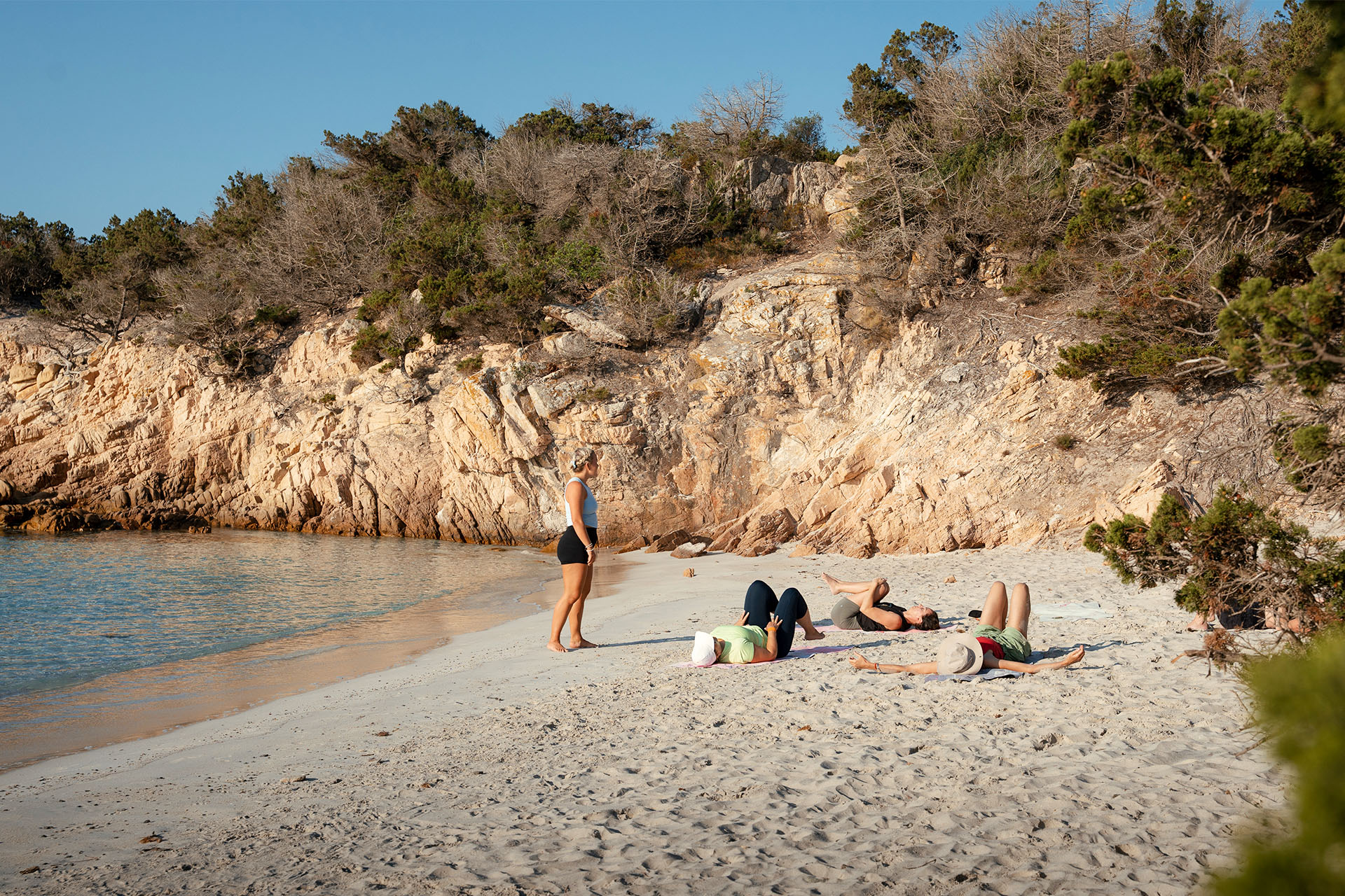 Agave guests on Sardinian beach yoga with guide, La Maddalena, Italy
