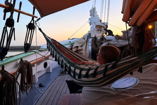 Aron of svendborg guest on deck at sunset relaxing in hammock, Scandinavia