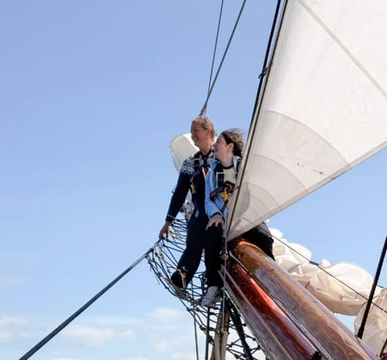 Aron tall ship guests on bowsprit sailing in SCandinavia