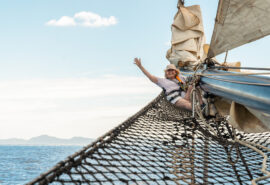 Blue Clipper guest onboard Blue Clipper on bowsprit female sailor