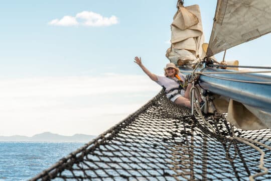 Blue Clipper guest onboard Blue Clipper on bowsprit female sailor