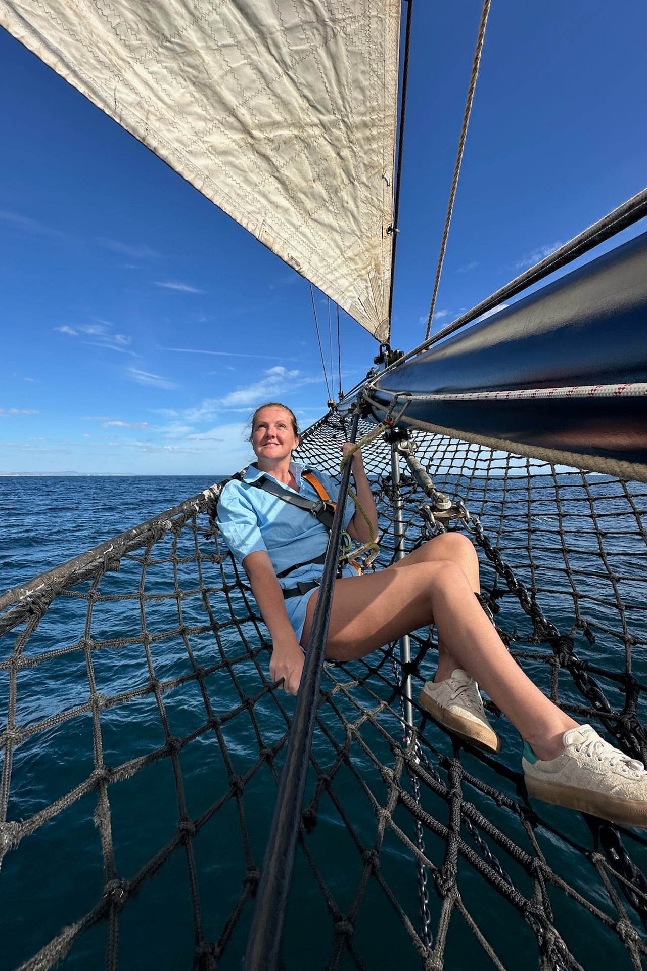 Blue Clipper guest relaxing on bowsprit tall ship sailing