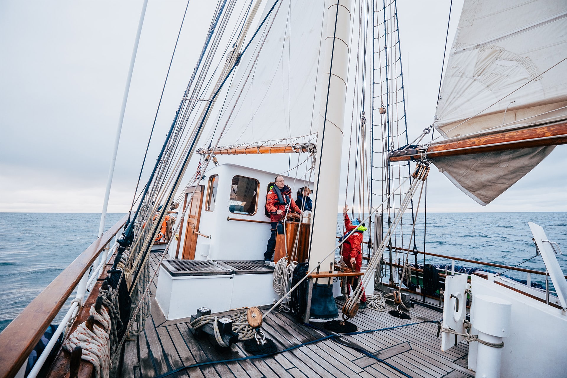 Blue Clipper guests at helm sailing on deck