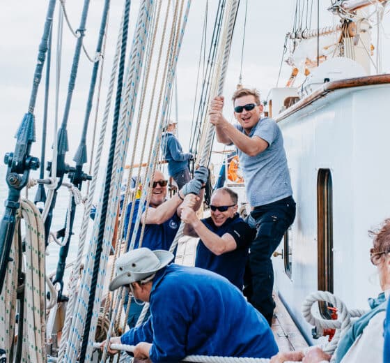 Blue Clipper guests raising sails tall ship