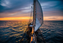 Blue Clipper tall ship from bowsprit at sunset