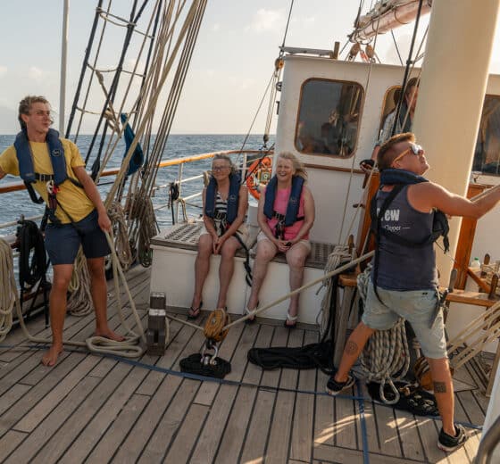 Blue Clipper tall ship guests on deck pulling ropes
