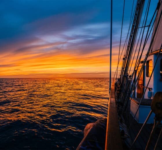 Blue Clipper tall ship on deck at sunset