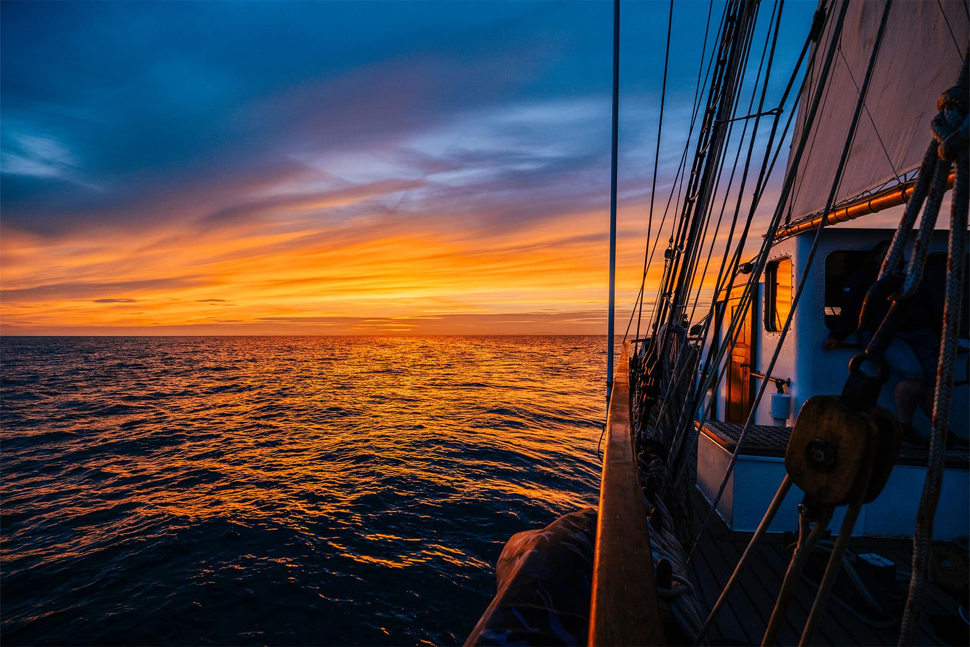 Blue Clipper tall ship on deck at sunset