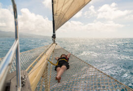 Chronos guest relaxing on bowsprit net yacht