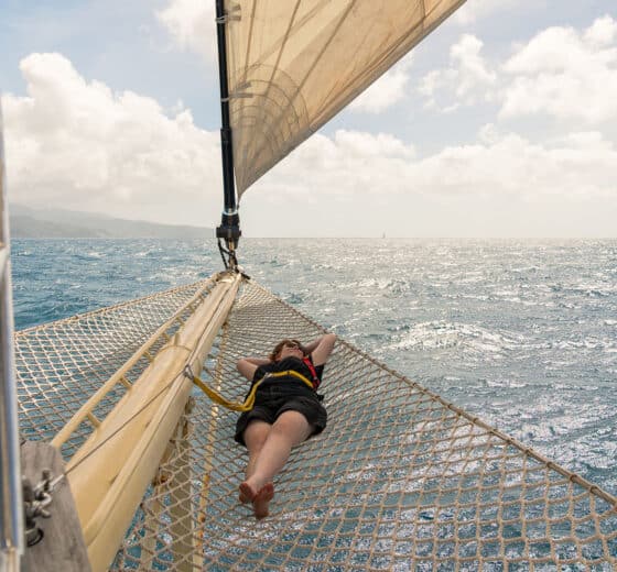 Chronos guest relaxing on bowsprit net yacht