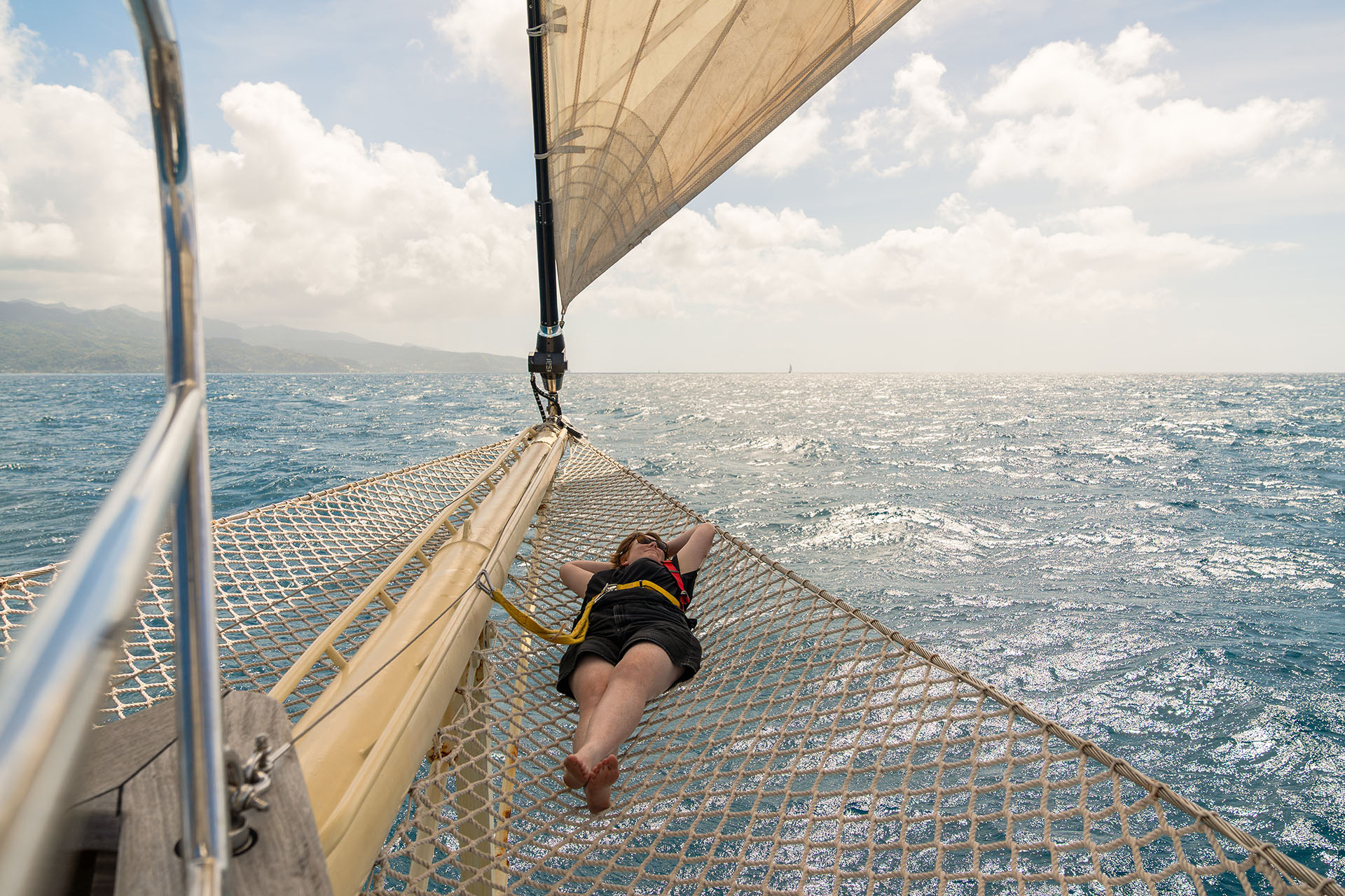 Chronos guest relaxing on bowsprit net yacht
