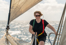 Chronos guest venturing onto bowsprit female solo sailor