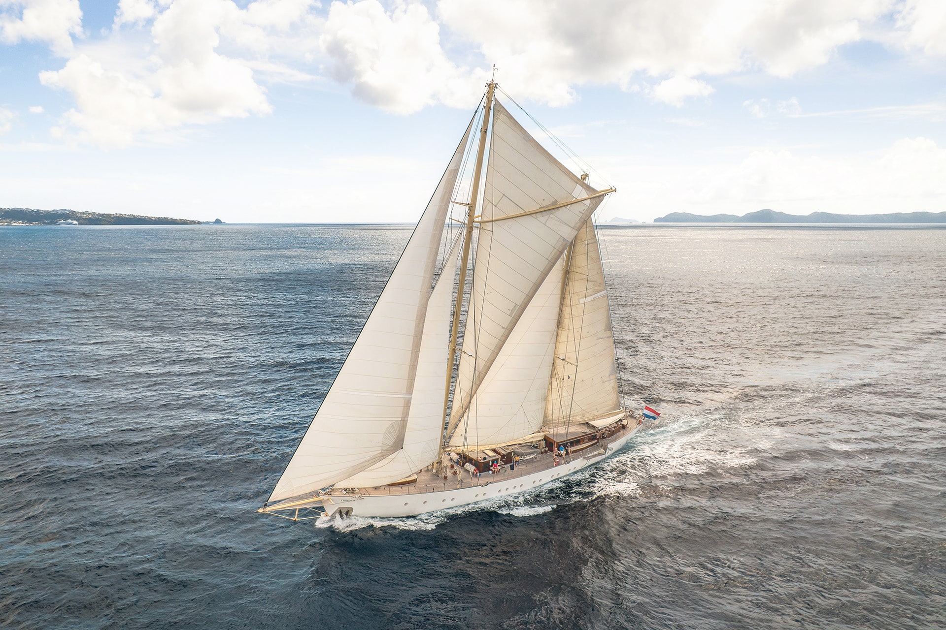 Chronos yacht underway full sail sailing off coast