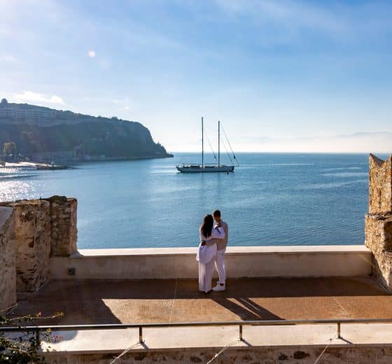 Couple looking at view of Kairos anchored in Mediterranean