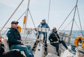 Emma Claire onboard guests at helm on deck Devon