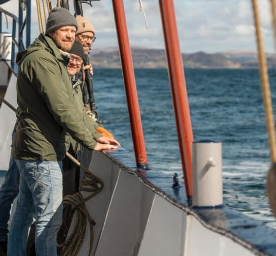 Flying Dutchman guests enjoying the coastal views onboard in the Hebrides, Scotland