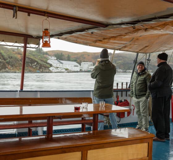 Flying Dutchman guests on deck relaxing with coffee taking in the views of the Hebrides, Scotland