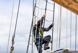 Guest climbing the rigging on Blue Clipper