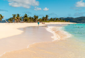 Guest walking along sandy beach off Carriacou, Grenada, Caribbean