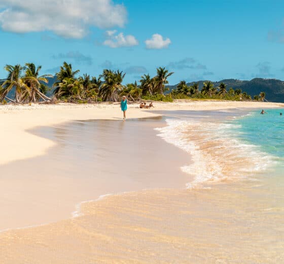 Guest walking along sandy beach off Carriacou, Grenada, Caribbean