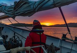 Guest watching sunset on deck of Blue Clipper