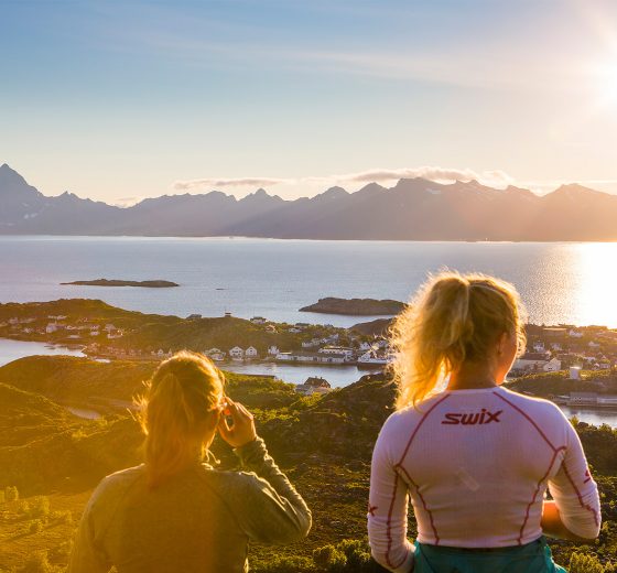 Guests hiking in summer sunshine Lofoten islands Norway
