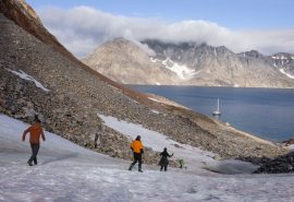 Guests hiking in Greenland with Valiente anchored