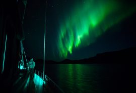 View of guests on expedition yacht Valiente with the Northern Lights