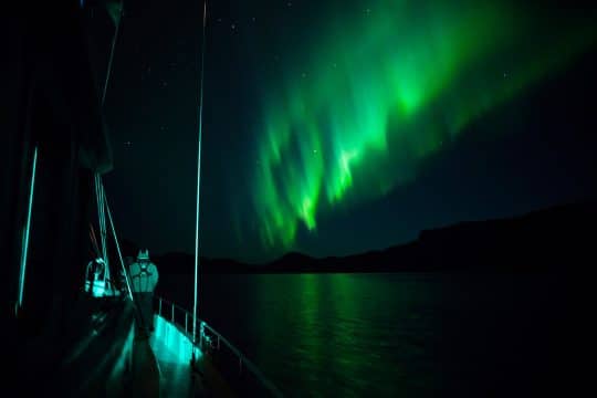 View of guests on expedition yacht Valiente with the Northern Lights