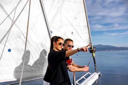 Guests on bowsprit of yacht Kairos