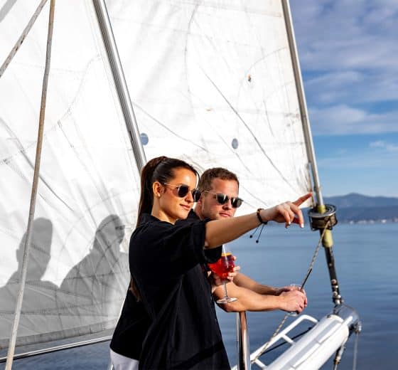Guests on bowsprit of yacht Kairos