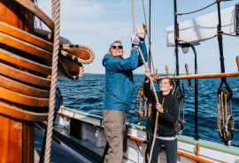 Guests pulling ropes on board Aron, South Funen, Denmark
