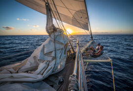 Guests relaxing on bowsprit at sunset SC Chronos Rhea