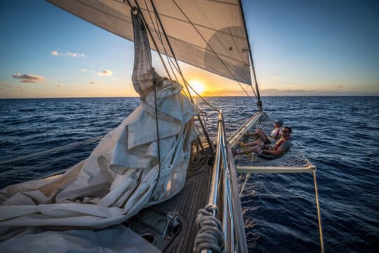 Guests relaxing on bowsprit at sunset SC Chronos Rhea