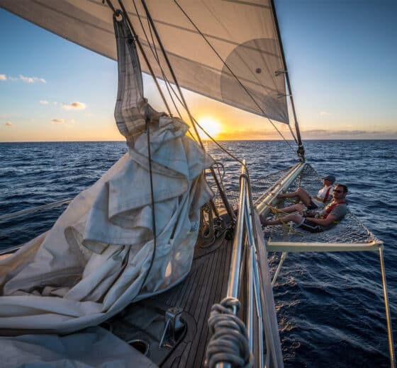 Guests relaxing on bowsprit at sunset SC Chronos Rhea