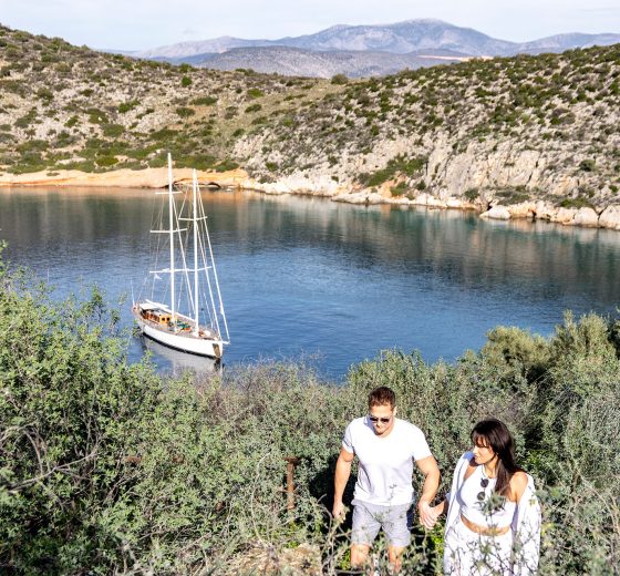 Guests walking ashore with Kairos anchored in bay Greece
