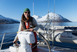 Humla guest onboard at helm in Northern Norway winter sailing