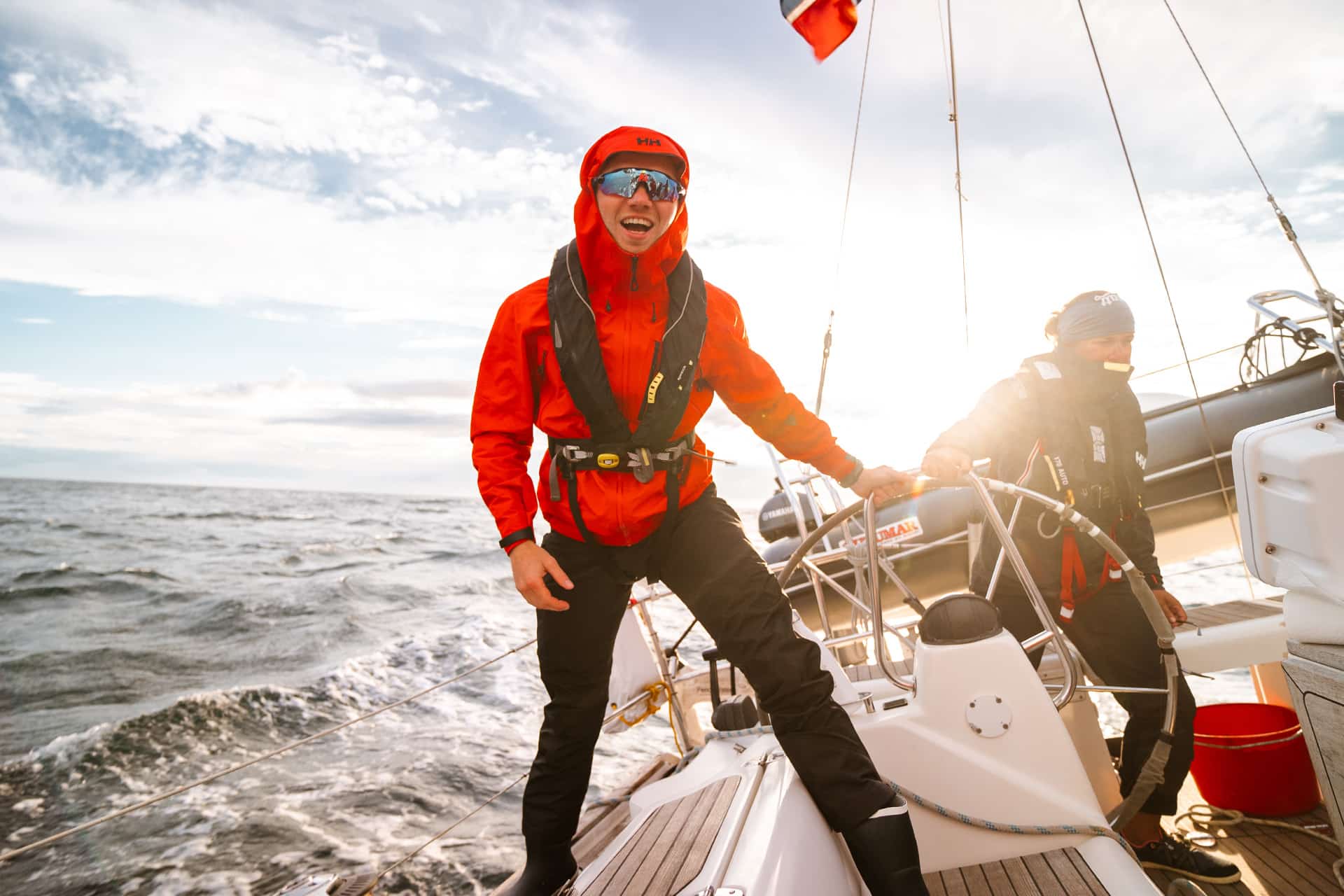 Humla guests sailing underway at helm in Lofoten islands, Norway, adventure
