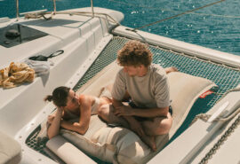 Ingrid More catamaran guests relaxing on nets onboard summers day