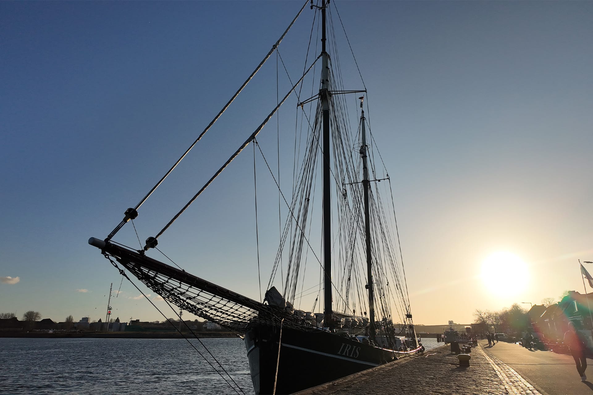 Iris tall ship alongside sunset baltic sea