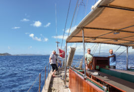 Kairos guest on deck underway sailing in the BVIs British Virgin Islands at helm