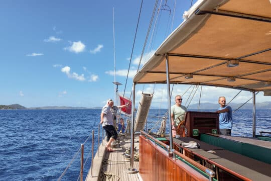 Kairos guest on deck underway sailing in the BVIs British Virgin Islands at helm