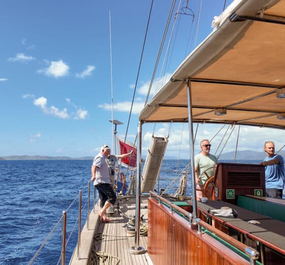 Kairos guest on deck underway sailing in the BVIs British Virgin Islands at helm