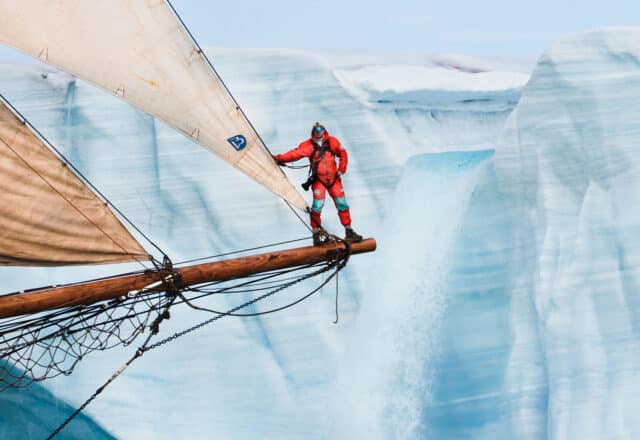 Linden expedition leader Joe onboard on bowsprit in the Arctic Greenland
