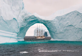 Linden tall ship beneath glacier iceberg arctic circle sailing Greenland