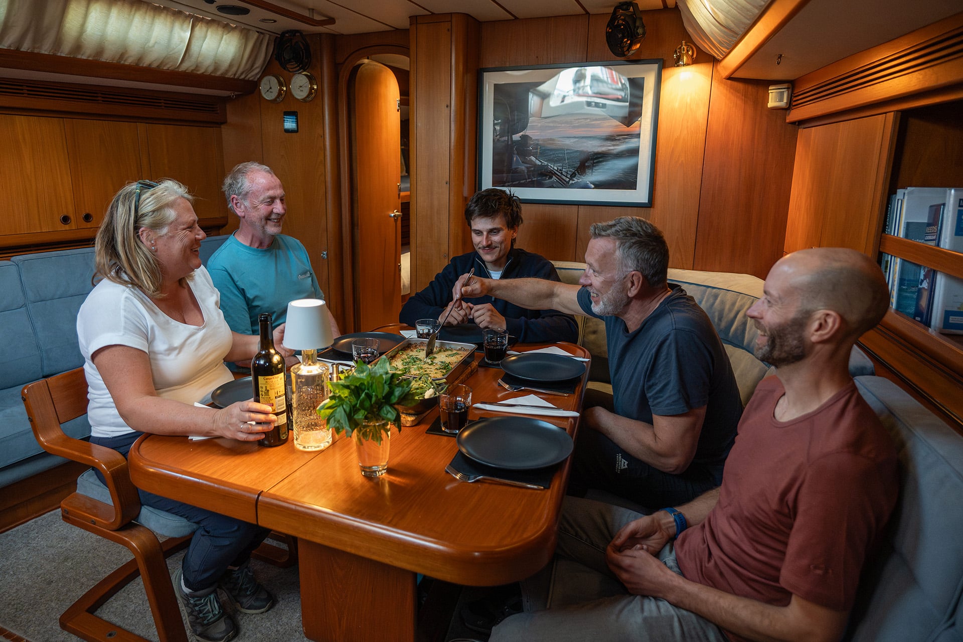 Noonmark VI adventure yacht below deck interior guests enjoying meal onboard dining dinner