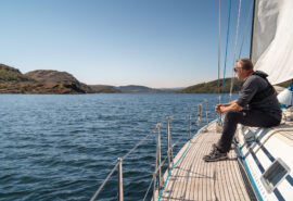 Noonmark VI adventure yacht sailing guest sitting on deck in the hebrides Scotland