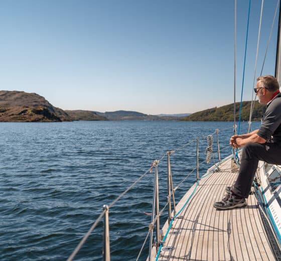 Noonmark VI adventure yacht sailing guest sitting on deck in the hebrides Scotland