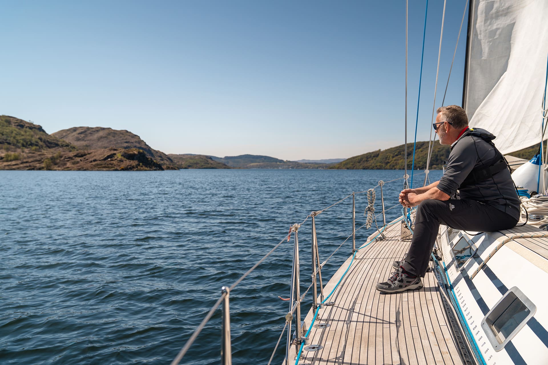 Noonmark VI adventure yacht sailing guest sitting on deck in the hebrides Scotland